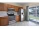 Well-lit kitchen featuring stainless steel appliances and a sliding glass door to the backyard at 4658 Sabal Key Dr, Bradenton, FL 34203
