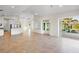 Open living room and kitchen with tile floors and lots of natural light through sliding glass doors at 4941 Sabal Lake Cir, Sarasota, FL 34238
