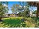 Beautifully landscaped backyard with a lush lawn, mature trees, and the house, creating a serene outdoor space at 503 Park Dr, Bradenton, FL 34209