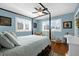 Stylish bedroom featuring a four-poster bed, ceiling fan, and bright blue walls at 503 Park Dr, Bradenton, FL 34209