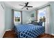 Bedroom with two windows dressed with light-filtering curtains and blue patterned bedspread at 503 Park Dr, Bradenton, FL 34209