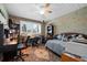 Cozy bedroom with a ceiling fan, a daybed, a desk, wood-paneled walls and a large window with shutters at 503 Park Dr, Bradenton, FL 34209