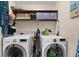 Well-equipped laundry room with washer, dryer, and overhead shelving at 503 Park Dr, Bradenton, FL 34209