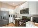 Well-appointed kitchen with stainless steel appliances, white cabinets and a modern backsplash at 513 Woodstork Cir, Bradenton, FL 34209