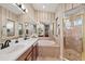 Elegant bathroom showcasing a large mirror, double sinks, a garden tub and a walk-in shower at 5141 Lansdowne Way, Palmetto, FL 34221