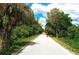 Paved bike trail bordered by lush greenery and trees, ideal for outdoor recreation and exercise at 515 Rousseau Dr, Nokomis, FL 34275