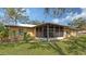 Exterior view of the home's screened lanai and well-maintained lawn at 515 Rousseau Dr, Nokomis, FL 34275