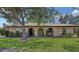 Inviting single-story home with a lovely lawn and a cozy, covered entryway framed by archways at 515 Rousseau Dr, Nokomis, FL 34275