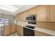 Kitchen showcasing stainless steel appliances, bright countertops, and a built-in microwave at 515 Rousseau Dr, Nokomis, FL 34275