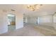Bright, spacious living room featuring an elegant chandelier, neutral walls, and an adjacent kitchen area at 515 Rousseau Dr, Nokomis, FL 34275