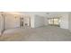 Large living room with sliding glass doors, a chandelier, and multiple doorways for seamless flow throughout the home at 515 Rousseau Dr, Nokomis, FL 34275