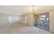 Open living area with a decorative chandelier, sliding glass doors, and white walls, awaiting your personal touch at 515 Rousseau Dr, Nokomis, FL 34275