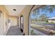 Inviting covered porch featuring tile flooring, an arched entryway, and a view of the surrounding landscape at 515 Rousseau Dr, Nokomis, FL 34275