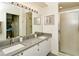 Bathroom with double sinks, framed mirrors, and walk-in shower with glass door at 5320 Hyland Hills Ave # 2222, Sarasota, FL 34241