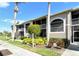 Close-up of condo building with palm trees and manicured landscaping and walkway at 5320 Hyland Hills Ave # 2222, Sarasota, FL 34241