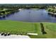 Aerial view of golf course driving range, golf carts, and golfers, with a view of lake at 5320 Hyland Hills Ave # 2222, Sarasota, FL 34241