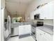 Bright kitchen with stainless steel appliances, white cabinets, and view to living area at 5320 Hyland Hills Ave # 2222, Sarasota, FL 34241