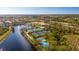 Extensive tennis and sport courts near a tranquil lake with a fountain and community clubhouse in this aerial view at 5539 Octonia Pl, Sarasota, FL 34238