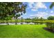 Picturesque backyard view of lush green lawn, shimmering lake and mature trees and foliage at 5539 Octonia Pl, Sarasota, FL 34238