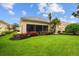 Exterior view of the home's screened in lanai, surrounded by vibrant landscaping and lush green lawn at 5539 Octonia Pl, Sarasota, FL 34238