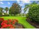 Well-maintained lawn and landscaping with vibrant flowers edging the lake behind this property at 5539 Octonia Pl, Sarasota, FL 34238