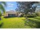 Spacious backyard showcasing a manicured lawn and a glimpse of the home's exterior at 5539 Octonia Pl, Sarasota, FL 34238