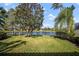 Beautiful backyard with lake views, well-manicured lawn, and tropical landscaping at 5539 Octonia Pl, Sarasota, FL 34238