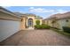 Welcoming front exterior with brick driveway, well-maintained landscaping, and an arched entryway, adding curb appeal at 5539 Octonia Pl, Sarasota, FL 34238