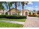 Charming single-story home featuring a well-manicured lawn, paver driveway, and lush tropical landscaping at 5539 Octonia Pl, Sarasota, FL 34238
