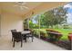 Enclosed lanai with ceiling fan, and outdoor seating area overlooking a manicured lawn and peaceful lake at 5539 Octonia Pl, Sarasota, FL 34238