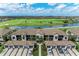 An aerial perspective of houses with attached garages, showcasing a well-planned community, pond, and golf course at 5710 Palmer Cir # 204, Lakewood Ranch, FL 34211