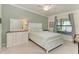 Comfortable bedroom featuring a dresser with mirror, full-size bed, neutral decor, and a bright window at 5710 Palmer Cir # 204, Lakewood Ranch, FL 34211