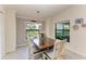 Bright dining room with a wooden table, white chairs, decorative plates, and two windows with beautiful views at 5710 Palmer Cir # 204, Lakewood Ranch, FL 34211