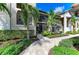 Condo exterior featuring a private entrance, screened lanai, lush landscaping, and a well-maintained walkway at 5710 Palmer Cir # 204, Lakewood Ranch, FL 34211