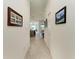 Bright hallway with neutral colors and decorative artwork, leading to the kitchen and living area at 5710 Palmer Cir # 204, Lakewood Ranch, FL 34211