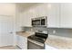 Close up on stainless steel range, granite counters, and white cabinets in modern kitchen design at 5710 Palmer Cir # 204, Lakewood Ranch, FL 34211