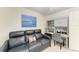 Cozy living room area with a blue leather sofa, built-in desk, shelving, and a colorful painting at 5710 Palmer Cir # 204, Lakewood Ranch, FL 34211
