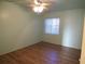 A cozy bedroom featuring wood flooring, a ceiling fan, and a window for natural light at 5889 Garden Ln # H4, Bradenton, FL 34207