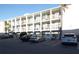 Three-story condo building featuring white paint, balconies, and ample parking for residents and guests at 5889 Garden Ln # H4, Bradenton, FL 34207
