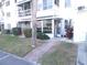 Charming condo building entrance featuring mature landscaping, walkway, and a screened-in porch at 5889 Garden Ln # H4, Bradenton, FL 34207