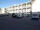 Exterior view of a multi-story condo building with ample parking and well-manicured landscaping at 5889 Garden Ln # H4, Bradenton, FL 34207