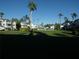 Wide exterior view showing condo building and lush grassy common area with tall palm trees at 5889 Garden Ln # H4, Bradenton, FL 34207