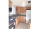 Galley kitchen featuring granite countertops, wood cabinets, and stainless steel appliances for a modern cooking experience at 5889 Garden Ln # H4, Bradenton, FL 34207