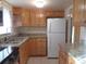 Kitchen featuring light wood cabinets, granite countertops and stainless-steel appliances, and tile flooring at 5889 Garden Ln # H4, Bradenton, FL 34207