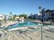 Community pool with lounge chairs and a clear blue sky surrounded by palm trees at 5889 Garden Ln # H4, Bradenton, FL 34207