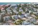 Aerial view of a charming neighborhood with homes near the beach, surrounded by lush greenery and palm trees at 6201 Holmes Blvd, Holmes Beach, FL 34217