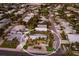 Aerial view showcasing a home's location within a residential neighborhood, featuring palm trees and manicured lawns at 6201 Holmes Blvd, Holmes Beach, FL 34217
