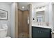 Modern bathroom featuring a glass-enclosed shower, vanity with storage and updated fixtures at 6201 Holmes Blvd, Holmes Beach, FL 34217