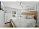 Bright bedroom with a ceiling fan, natural light, and comfortable wooden bed frame at 6201 Holmes Blvd, Holmes Beach, FL 34217