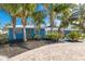 Charming blue home with lush landscaping and circular brick paver driveway at 6201 Holmes Blvd, Holmes Beach, FL 34217